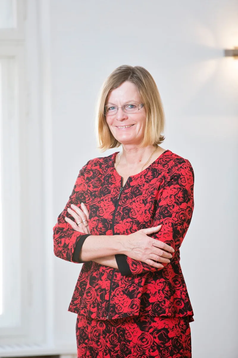 Birgit Zerjatke, Finanz- und Versicherungsmaklerin in Zwickau, mit verschränkten Armen in ihrem Büro